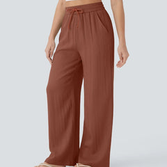 Rust brown wide-leg trousers with elastic waist and drawstring, full-length wide legs.
