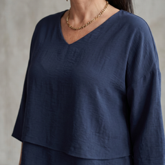 Navy layered V-neck top detail with short sleeves and necklace