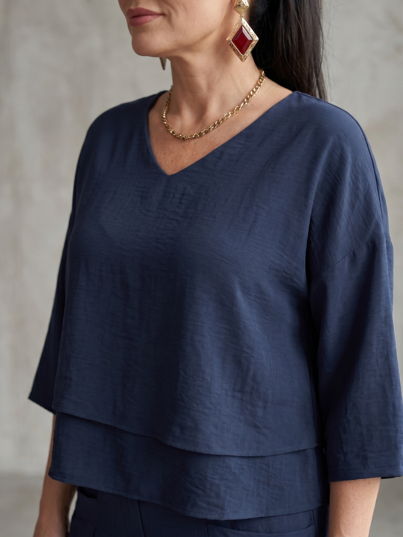 Navy layered V-neck top detail with short sleeves and necklace