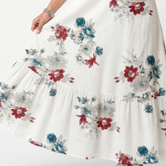 White floral midi dress detail, tiered skirt with multicolor blossom print.