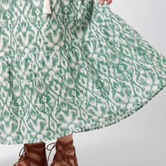 Green patterned midi dress fabric close-up with gathered tiered hem