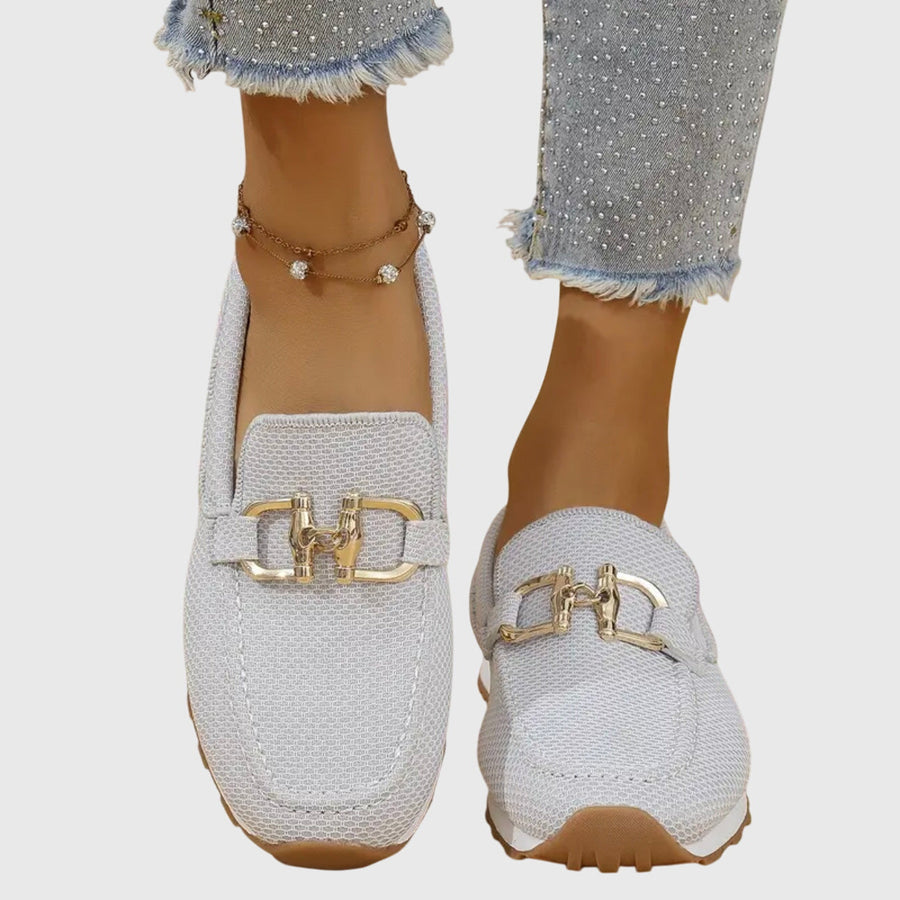 White orthopaedic loafer trainer with gold horsebit-style strap, textured knit and cushioned sole