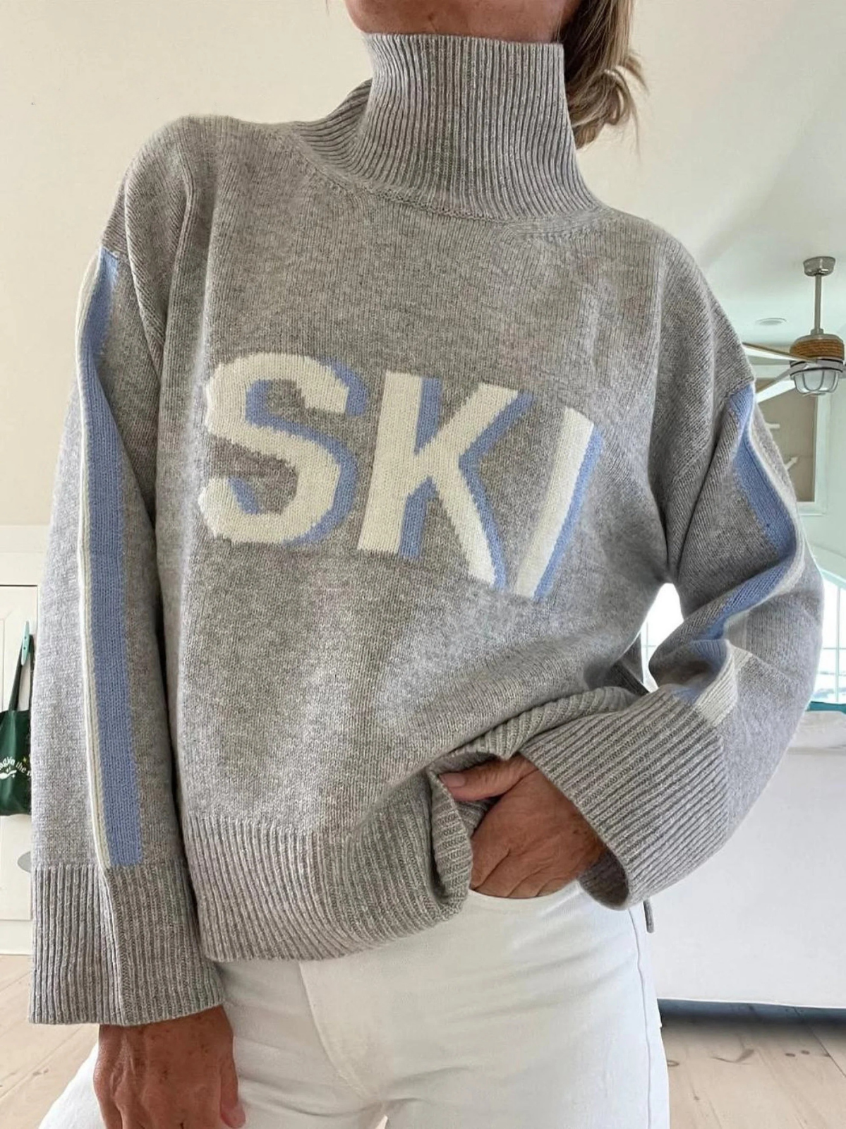 Gray retro turtleneck ski sweater with large blue “SKI” graphic