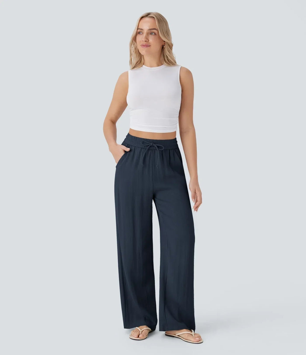 Navy blue wide-leg trousers with elastic waistband and drawstring, relaxed drape.