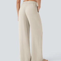 Beige wide-leg trousers with elastic waistband and drawstring, relaxed fit.