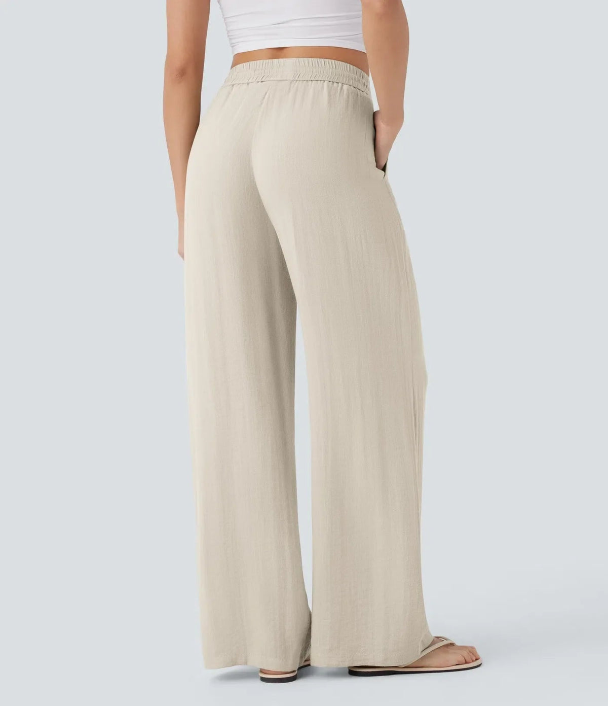 Beige wide-leg trousers with elastic waistband and drawstring, relaxed fit.