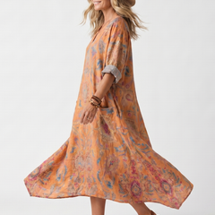 Orange printed midi dress with draped hem and cuffed elbow sleeves, side view