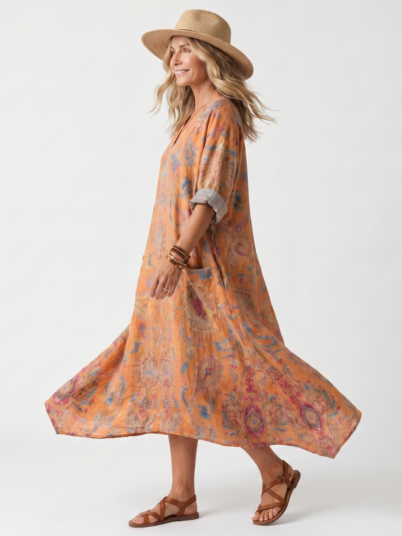 Orange printed midi dress with draped hem and cuffed elbow sleeves, side view