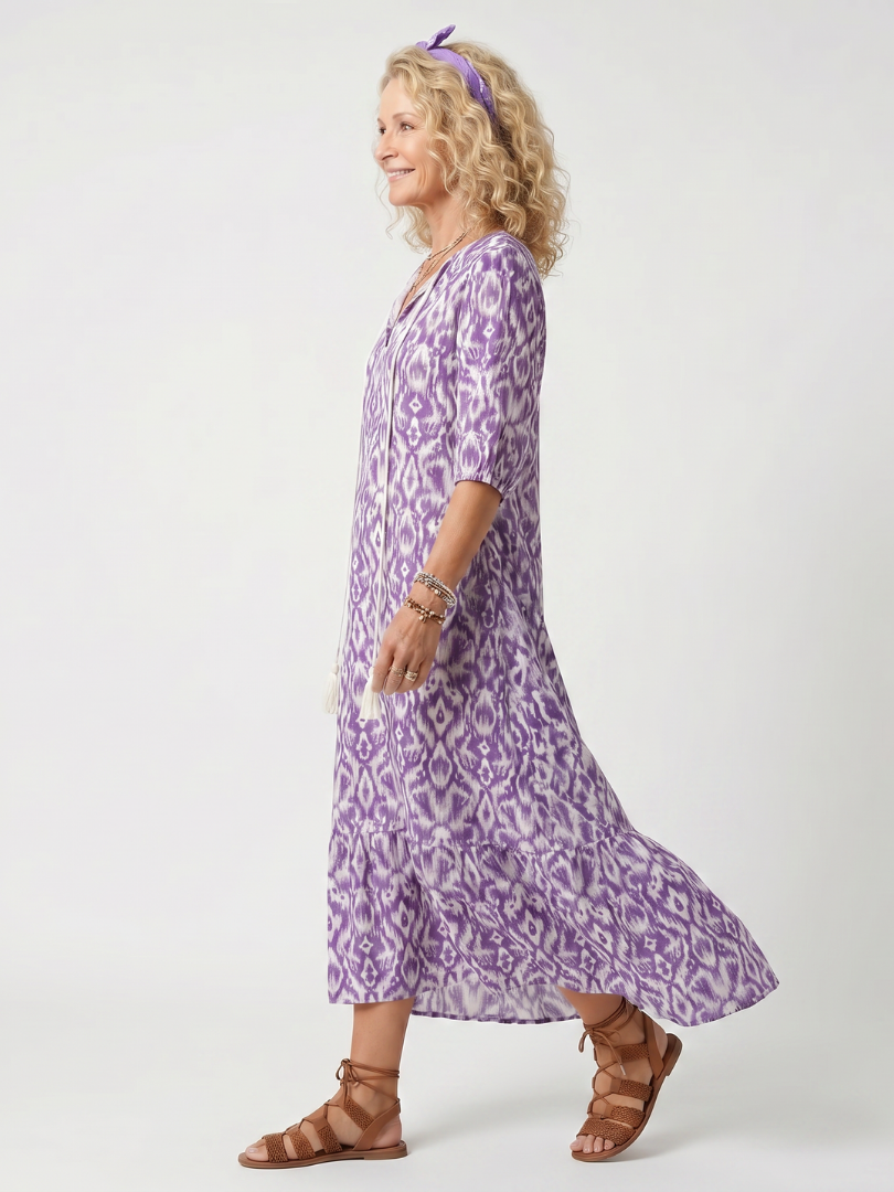 Purple printed midi dress with tie-neck and flowing tiered skirt, side view