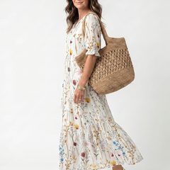 White botanical midi dress with tie-neck, gathered skirt flare, side view
