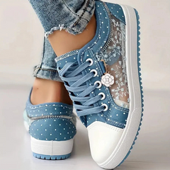 Light blue canvas sneakers with floral print panel, lace-up closure, thick blue-trim sole.