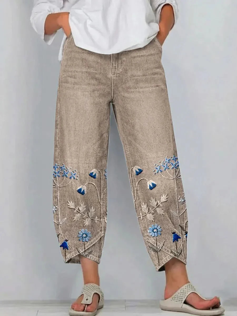 Khaki linen pants with embroidered floral panels on the lower legs