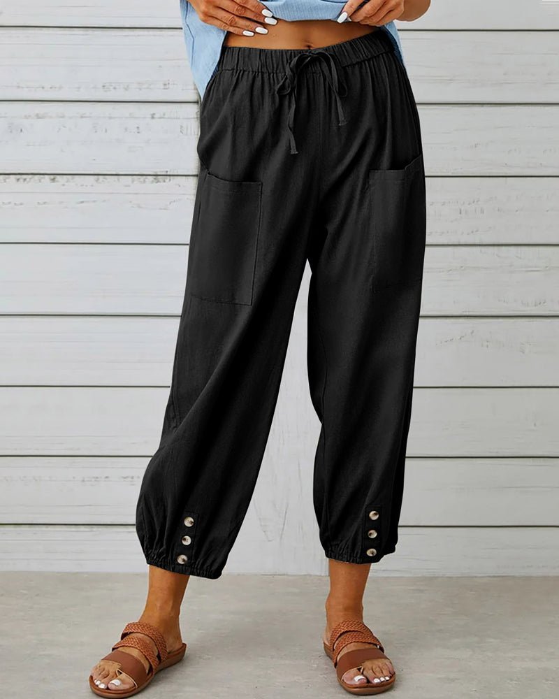 Black relaxed-fit trousers with elastic waist, drawstring, side pockets, button cuff hem.