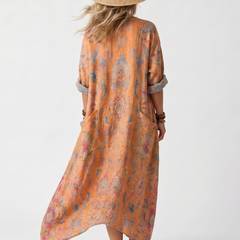 Orange printed midi dress, back view, with half sleeves and draped hem