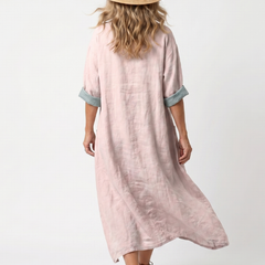 Pink midi dress back view with turquoise cuff trim and relaxed pocketed cut