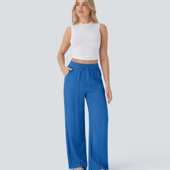 Blue wide-leg trousers with elastic waistband and drawstring, flowing drape.