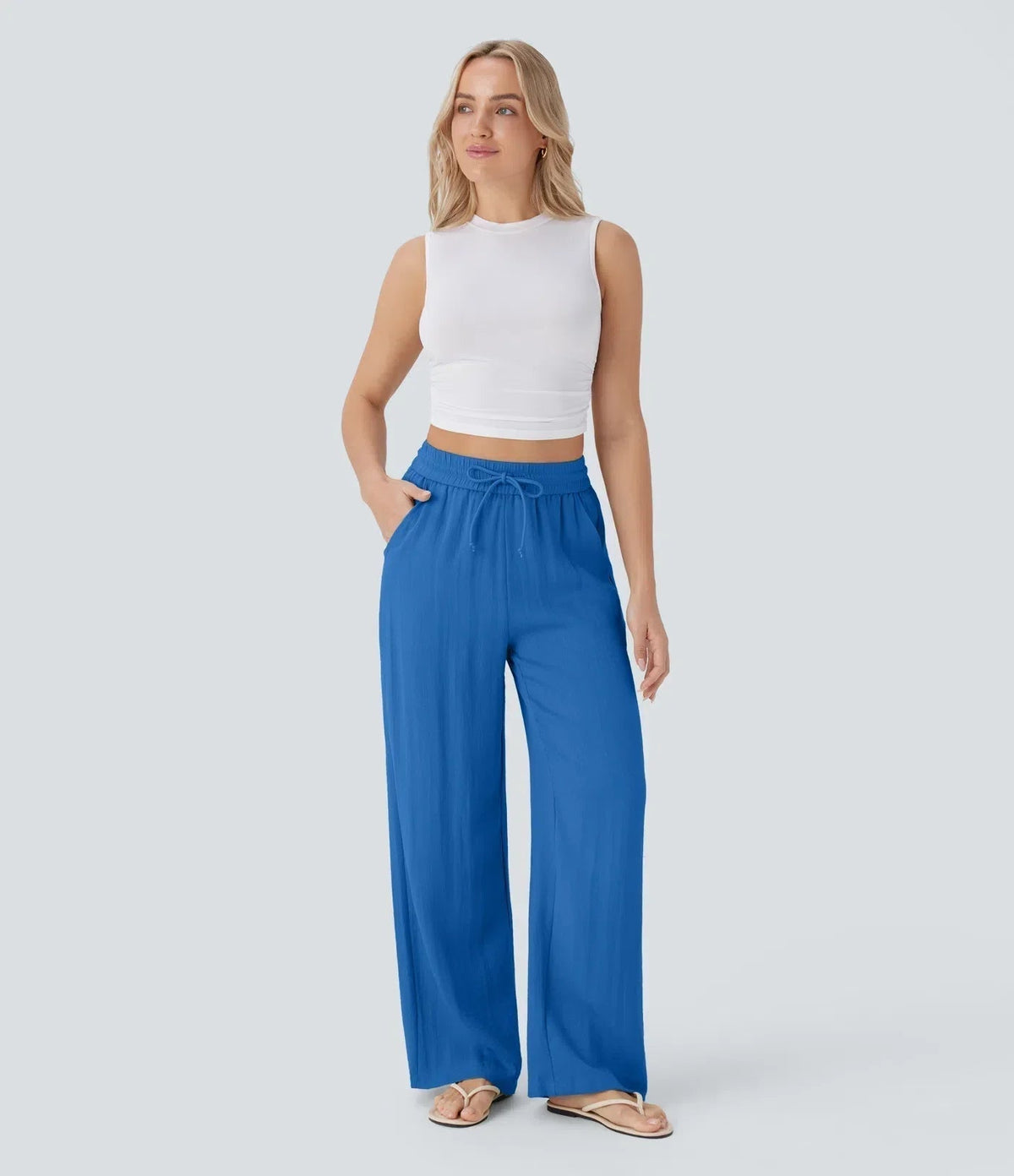 Blue wide-leg trousers with elastic waistband and drawstring, flowing drape.