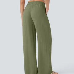Olive green wide-leg trousers with elastic waist and drawstring, long and loose.