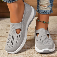 Light gray knit slip-on sneakers with side cutouts and cushioned white soles