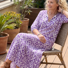 Purple printed midi dress with tie-neck, short sleeves, tiered skirt, seated