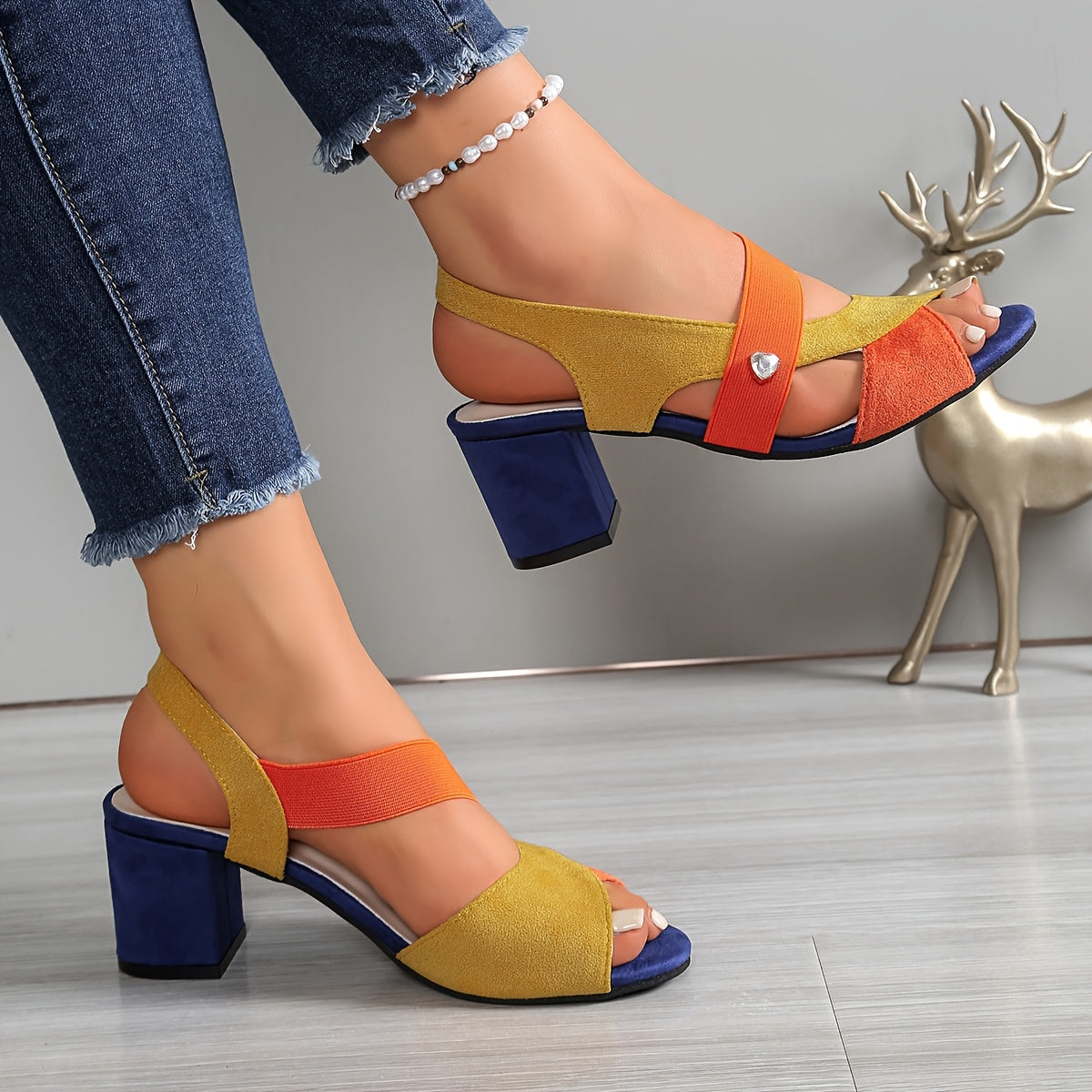 Orange, yellow, and blue suede block-heel sandals with wide straps and silver stud