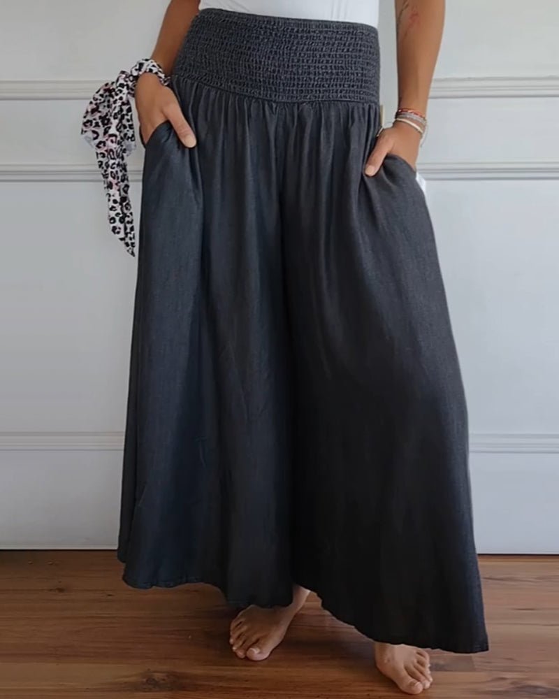 Grey relaxed-fit trousers with elastic waistband and wide, draped legs