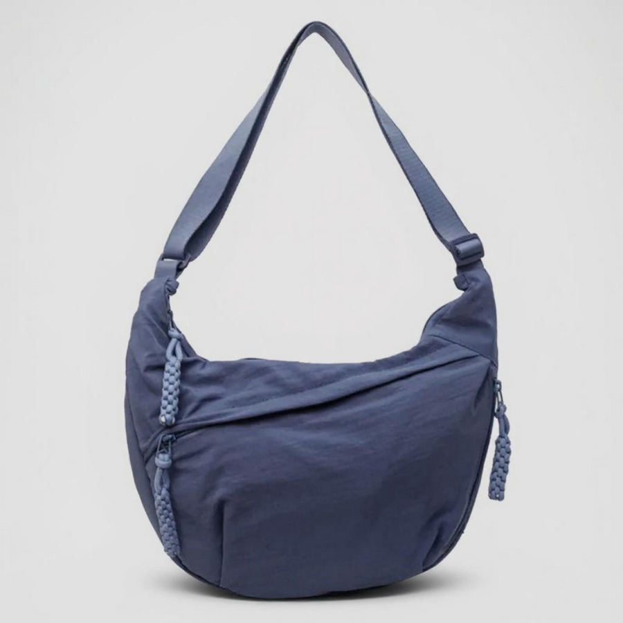 Blue classic shoulder bag with adjustable strap, tassel pulls, and zipper pocket