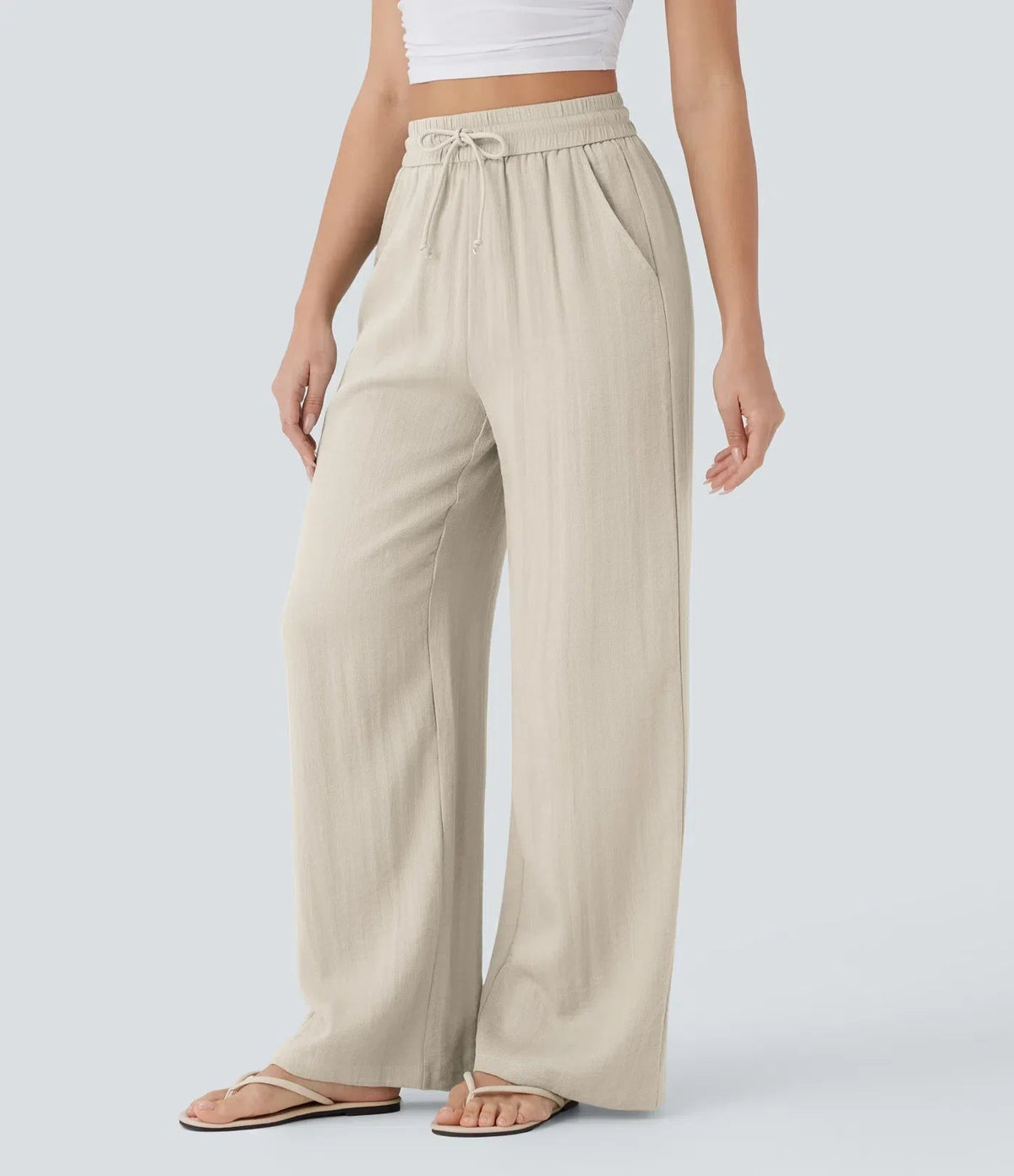 Beige wide-leg trousers with elastic waistband and drawstring ties, side view