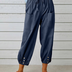Navy blue relaxed-fit trousers with elastic waist, drawstring, side pockets, button cuff hem.