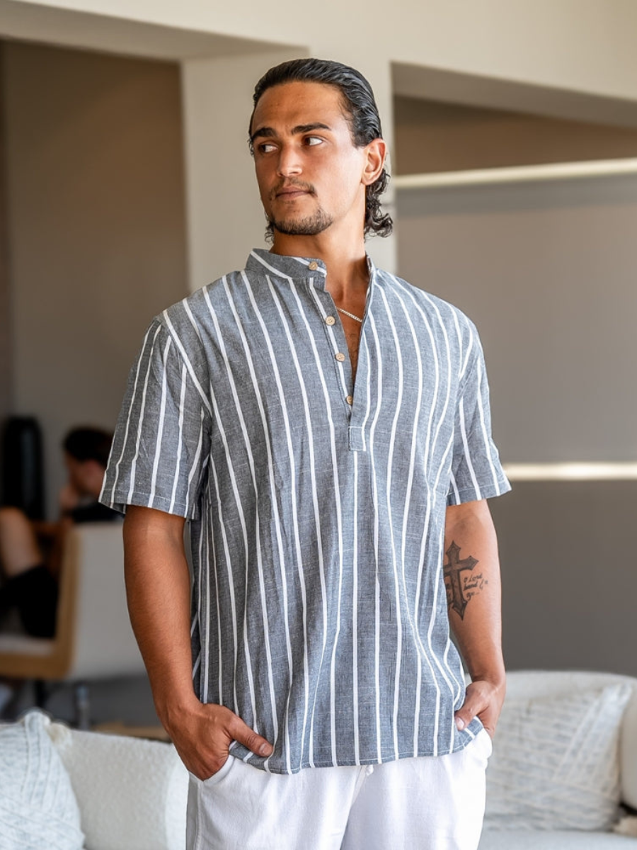 Men's striped polo shirt on model, blue with white vertical stripes, short sleeves and buttons