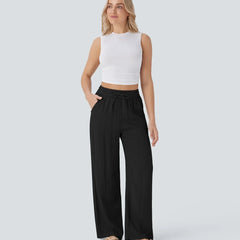 Black wide-leg trousers with elastic waist and drawstring, flowing straight legs.