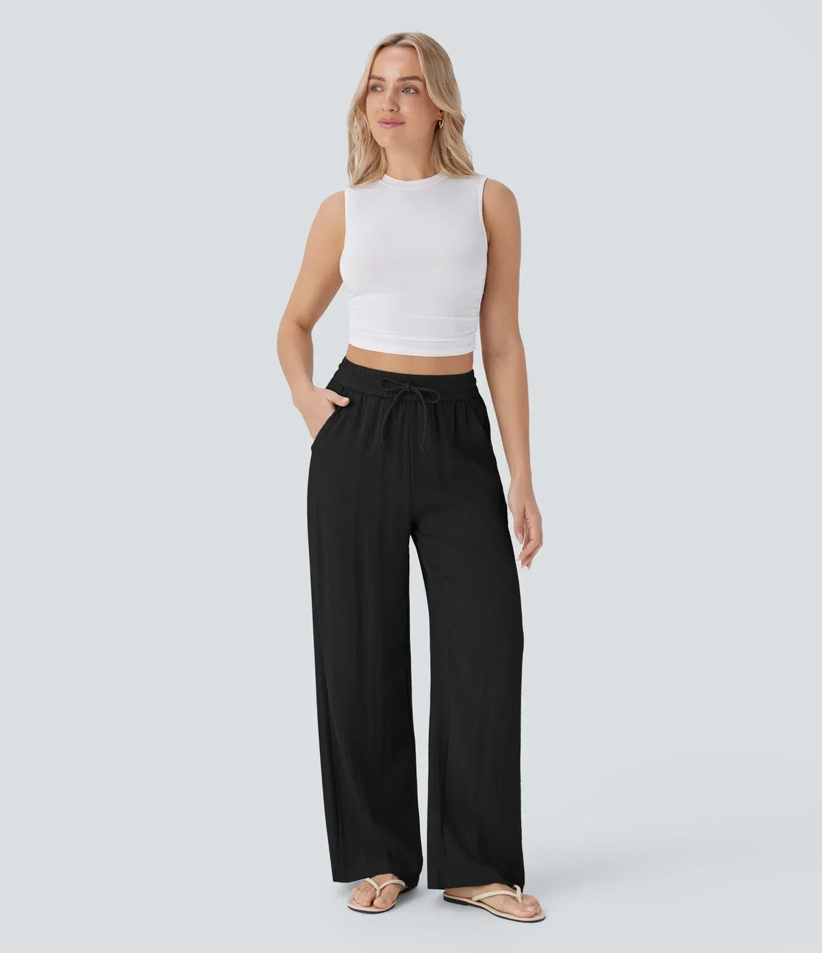 Black wide-leg trousers with elastic waist and drawstring, flowing straight legs.