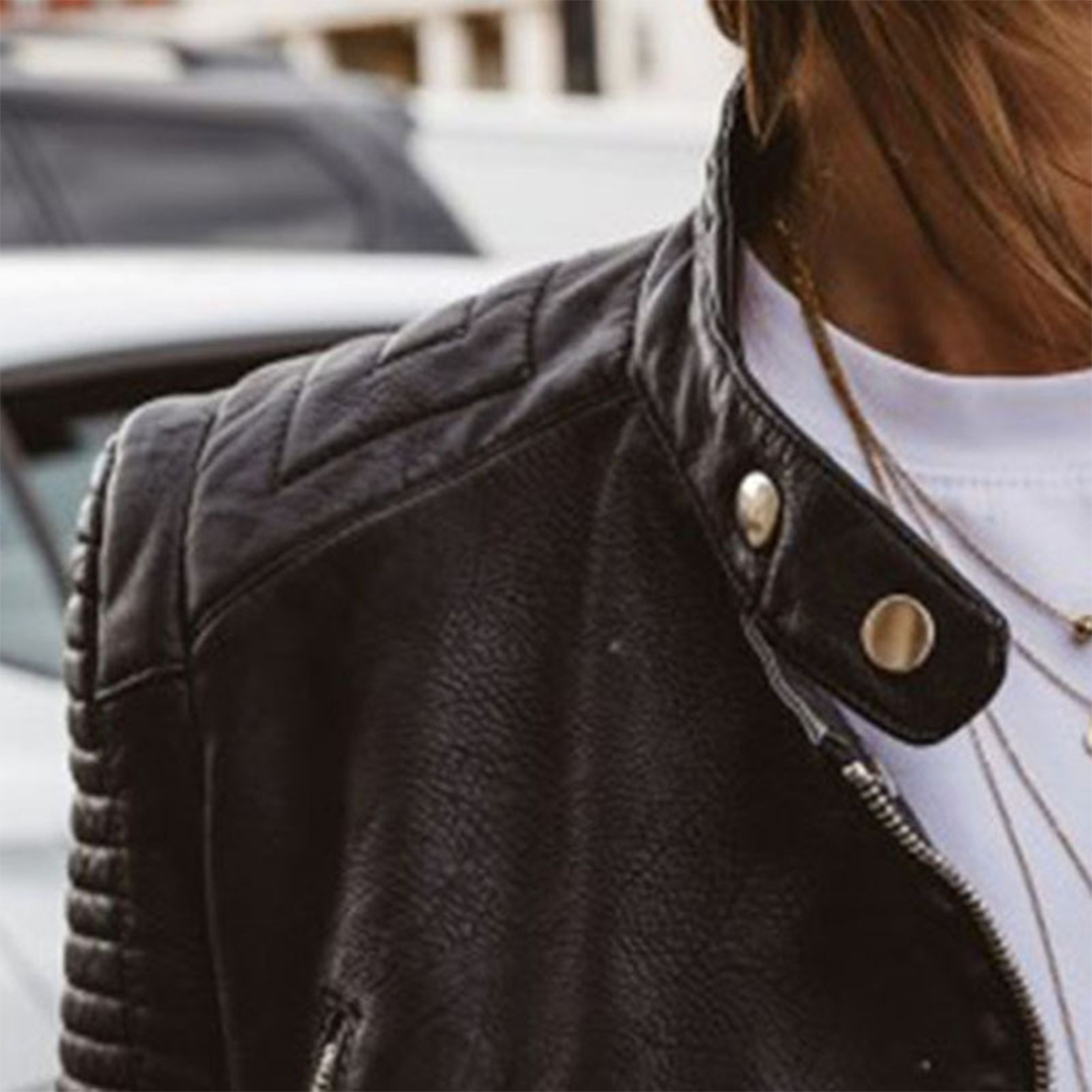 Dark leather jacket close-up: snap strap collar with metal zipper