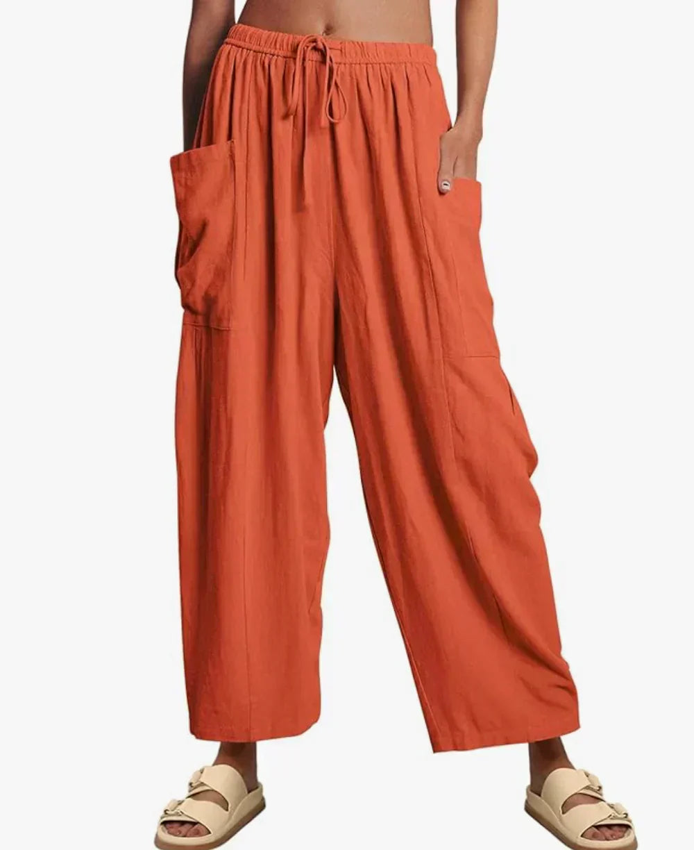 Orange wide-leg trousers with elastic waist and drawstring, side cargo pockets.