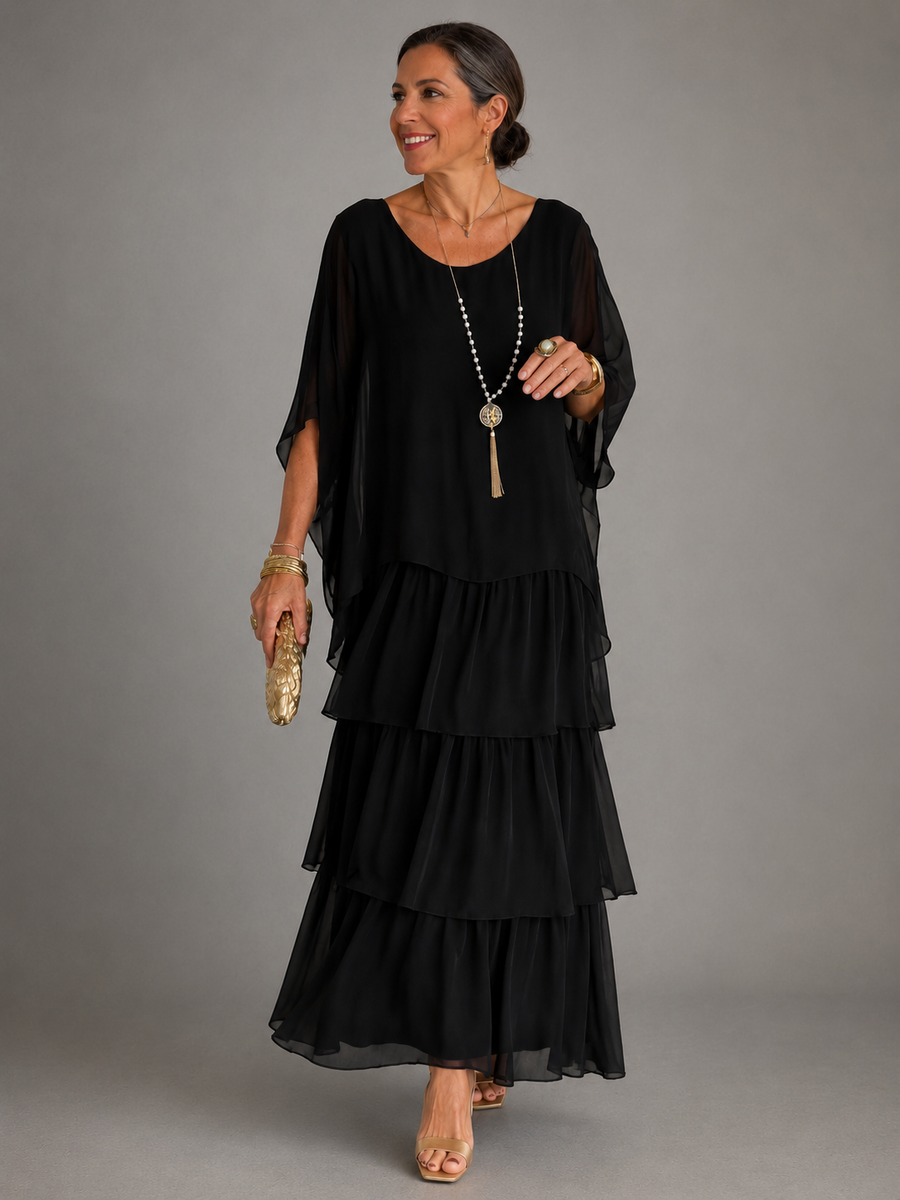Black tiered maxi dress with draped sleeves and layered ruffles; long pendant necklace