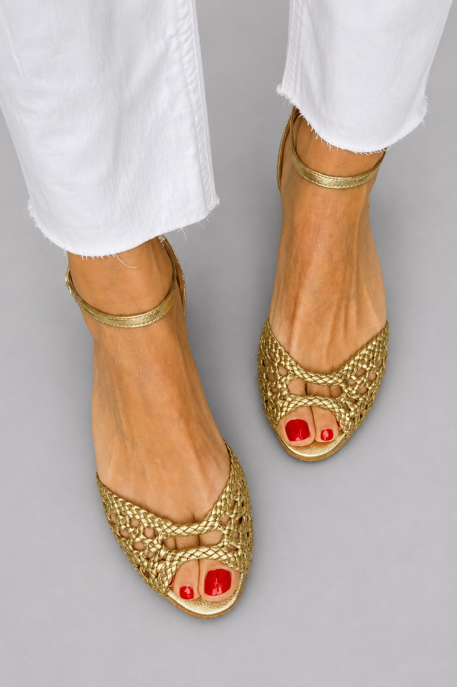 Gold woven slip-on sandals with ankle strap and open red toe detail