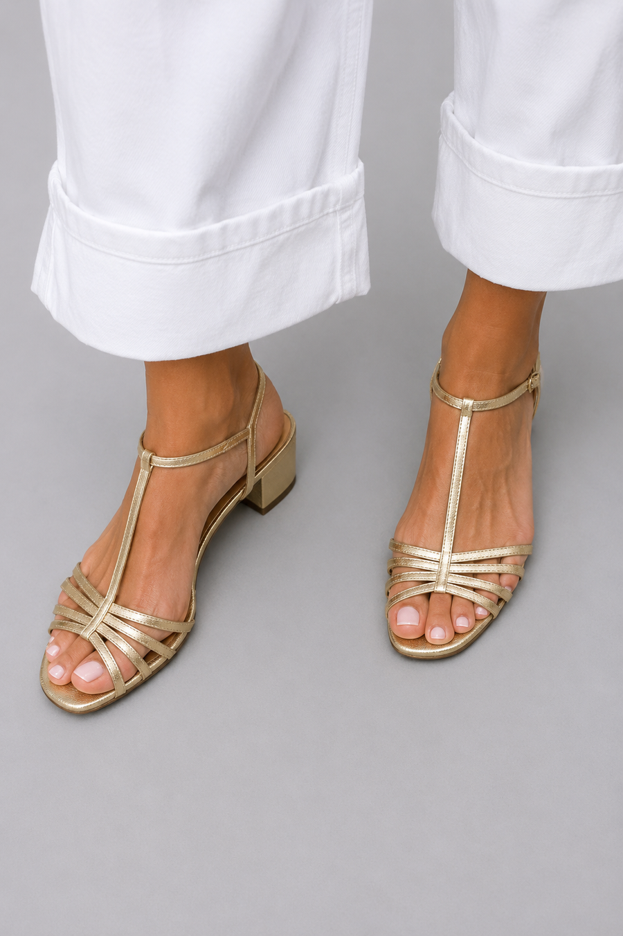 Gold strappy heeled sandals with open toe and ankle strap