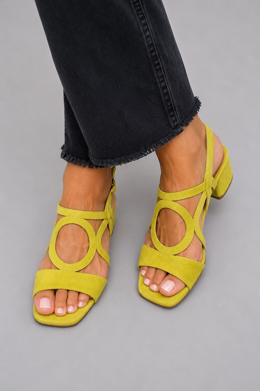 Yellow suede flat sandals with circular cutout straps and ankle tie, open-toe