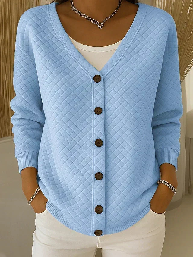 Blue quilted button-front cardigan with V-neck and long sleeves.