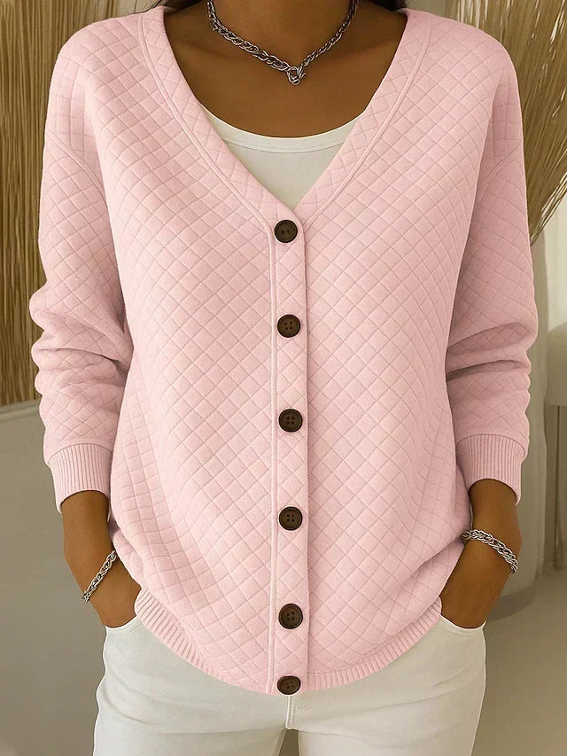 Pink quilted button-front cardigan with V-neck and long sleeves.