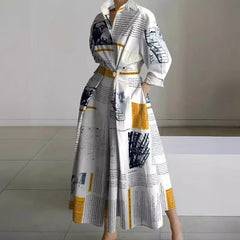 White maxi wrap collared dress with newspaper-style print and yellow accents, three-quarter sleeves