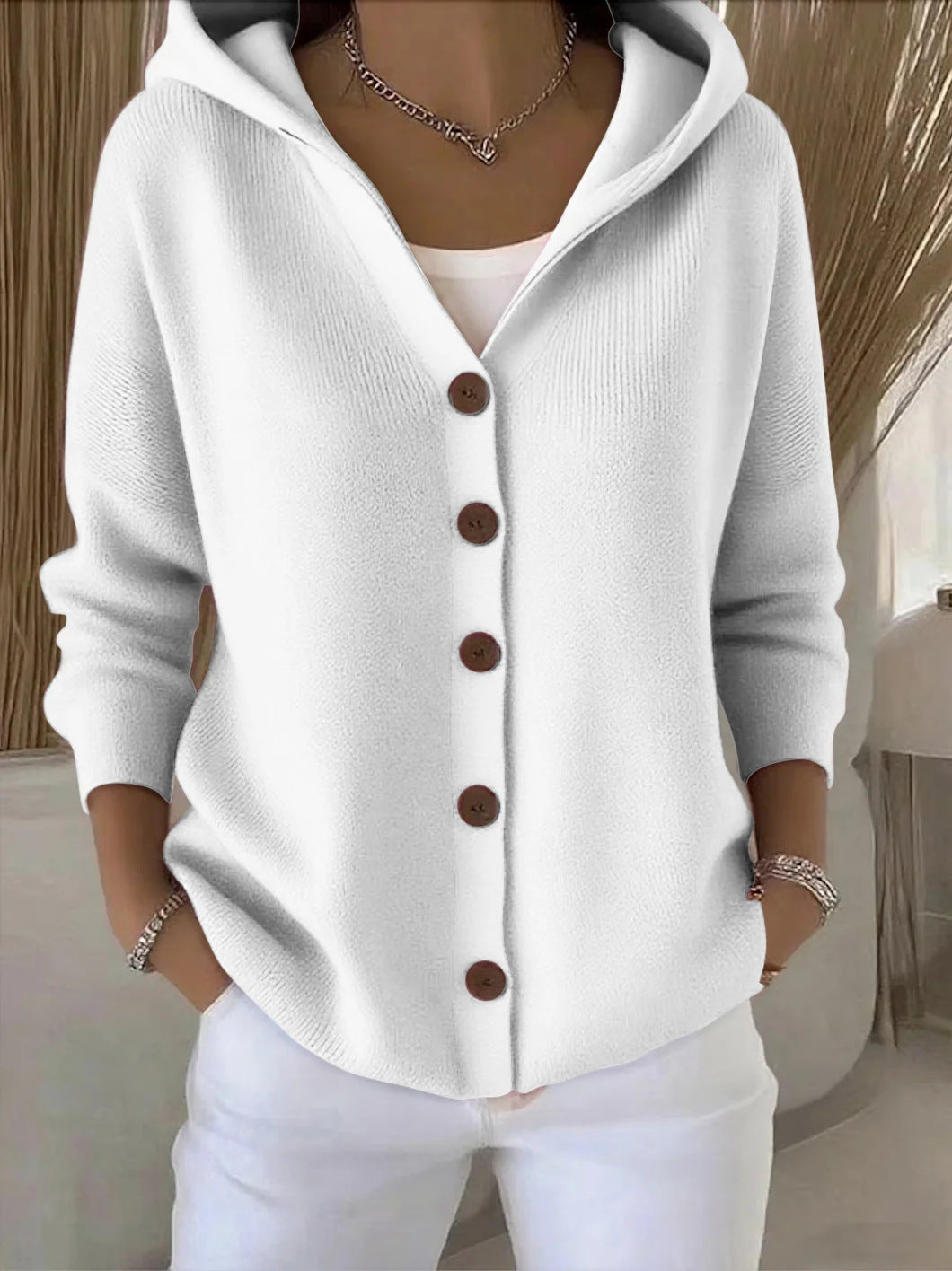 White hooded button-up knit cardigan with dark buttons, long sleeves