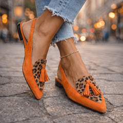 Sandali arancioni con motivo leopardo, cinturino alla caviglia e nappine arancioni.