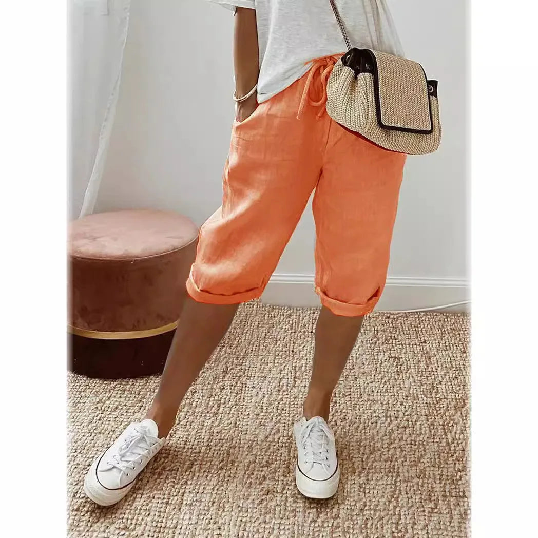 Lightweight summer shorts in orange, rolled hem, drawstring waist, side pockets.