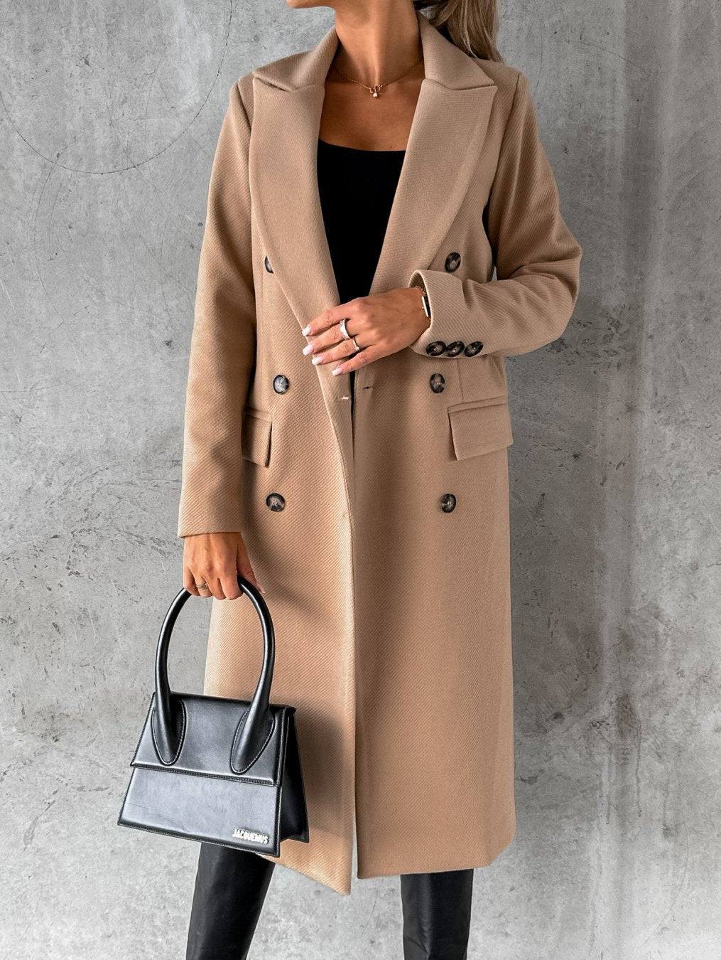 Tan longline double-breasted coat with notched lapels and flap pockets