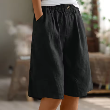 Relaxed summer shorts in black, elastic waistband and front button, knee length.