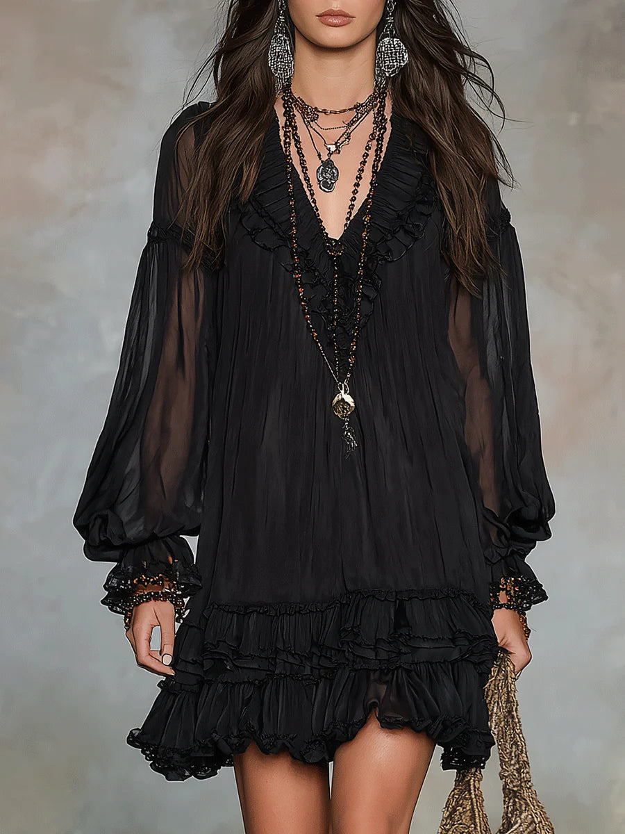 Black mini dress with V-neck, sheer puff sleeves, and tiered ruffle hem.
