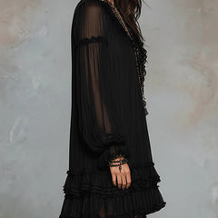 Black mini dress with sheer long sleeves and layered ruffle trim at hem and cuffs.