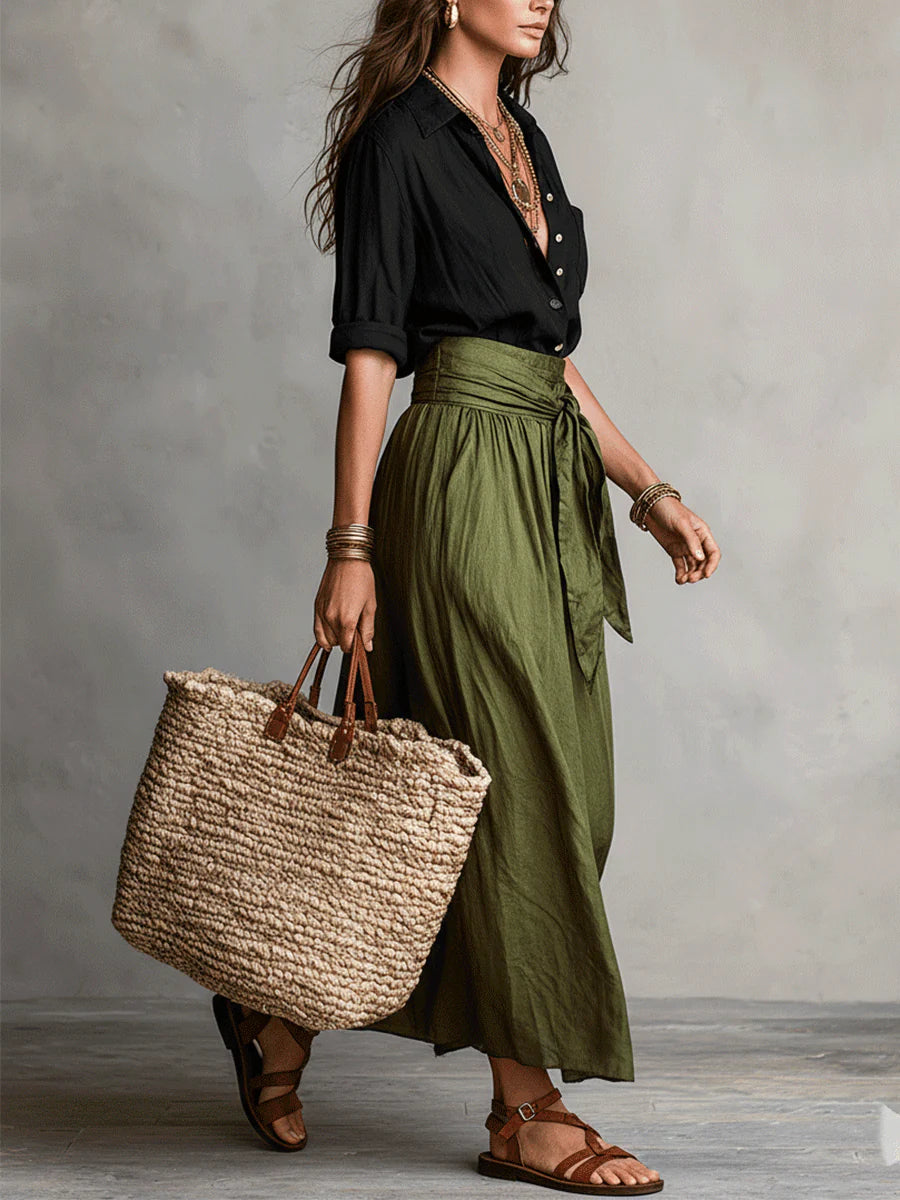 Black blouse top and olive green midi skirt two-piece set, side view with tote