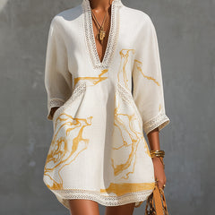 Ivory lace midi dress with V-neck, lace-trim cuffs, and gold abstract print